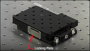 Cap screws secure two of four mounting slots of a linear translation stage to a table.